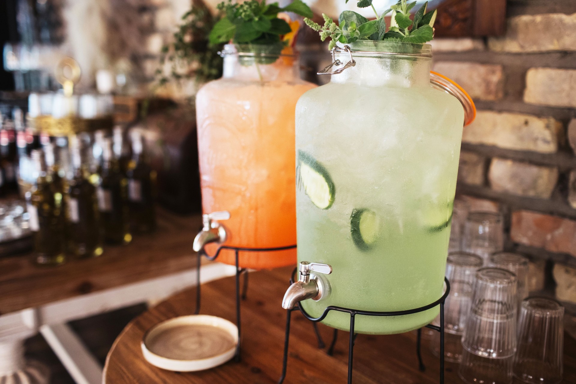Large glass jars of lemonade. Refreshing cucumber lemonade with dewdrops on the glass. Cool summer drink idea for parties and guests.